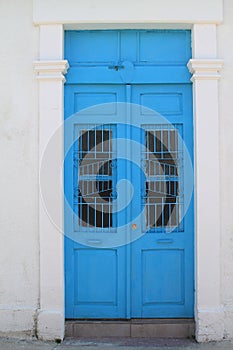 Blue front door in white stone wall