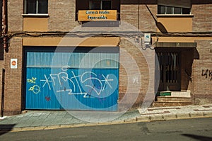 Blue garage gate and door on a brick building at Caceres