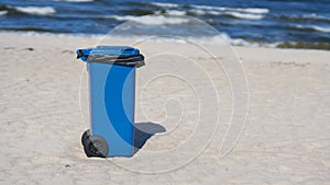 Blue garbage can on the beach of Swinoujscie in Poland