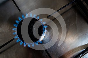 A blue gas flame is seen from the top coming from a household gas burner of a kitchen stove the top Due to Russia`s invasion of