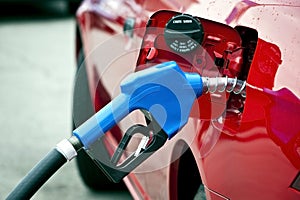 Blue Gas Nozzle Fueling Red Car