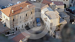 A blue gendarme car with flashing beacons on stands in an alley in the old town. City Patrol. Stone buildings with tiled