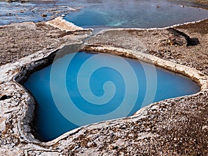 Blue geothermal pond at The Great Geysir, an active volcanic geyser in Southwestern Iceland