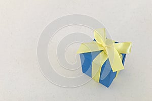 Blue gift box on beige recycle paper background , copy space.