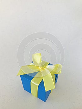 Blue gift box on beige recycle paper background . vertical.