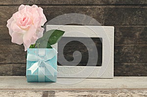 Blue gift box with blank frame and oink rose photo