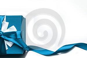 Blue gift box with bow and ribbon on a white background, isolated image