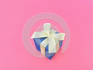 Blue gift box on bubblegum pink background.