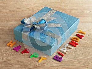 A blue gift box and happy birthday on blackboard