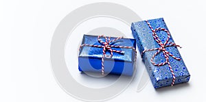 Blue gift box with red ribbons isolated on white background