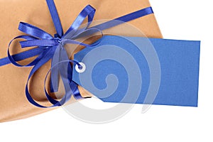 Blue gift tag or label on brown paper parcel or package, top view, close up