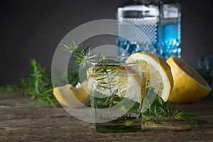 Blue gin , tonic and lemon on a old wooden table.