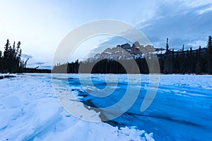 Blue glacier water flowing over ice in the bow river at Castle mountain