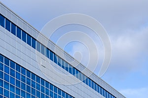 Blue glass building and sky with clouds