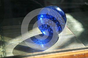 Blue glass crystal ball with bubbles. Magic sphere with light shing through the ball globe.