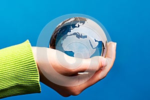 Blue glass globe in hand