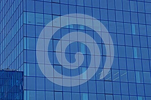 Blue glass texture of windows on the wall of a tall building