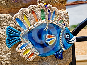 blue glazed ceramic ornament fish, turkish souvenir on stone wall, Side