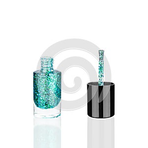Blue glittering nail polish glass bottle & brush white background isolated close up, open green sequin varnish, turquoise lacquer