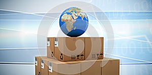 Composite image of blue globe on brown cardboard boxes