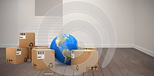 Composite image of blue globe with cardboard boxes