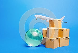 Blue globe, cardboard boxes and freight airplane. International world trade. Deliver goods, shipping. Import export freight