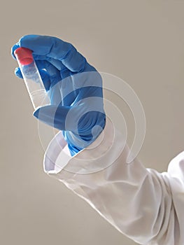 A blue glove with a test tube