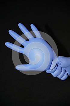 Blue gloved hand, holding a filled syringe, squirting down