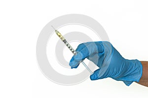 A blue-gloved hand holds a syringe, isolated