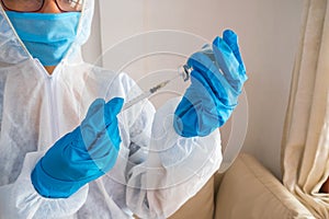 Blue gloved hands and syringe administering medicine in hospital