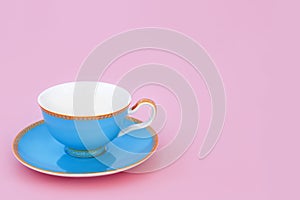 Blue and Gold Porcelain Tea Cup on Pink Background