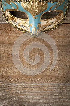Blue and gold venetian mask on wooden table
