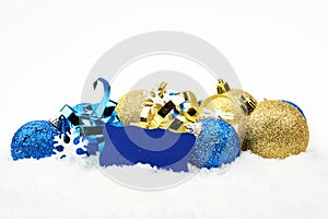 Blue,golden christmas decoration in line on snow with wishes card