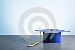 Blue graduation cap on wooden table