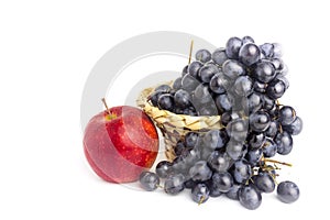 Blue grapes in basket and red apple isolated on white background