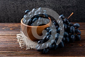 Blue grapes on dark wooden background