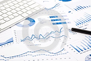 Blue graph and chart reports on office table photo