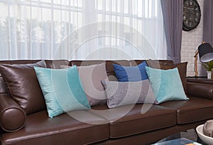 Blue and gray pillows on leather sofa in modern living room