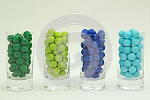 Blue and green colored candy drops in glass