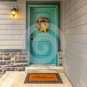 Blue green front door with a welcoming wreath