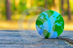 Blue and Green Globe on a Tree Stump