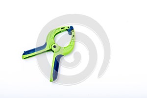 Blue and green lastic clamp on a white isolated background