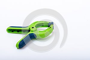 Blue and green lastic clamp on a white isolated background