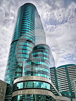 Blue Green Modern Building Against Blue Cloudy Sky