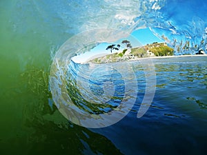 A Blue and Green Ocean Wave Breaks Near the Beach photo