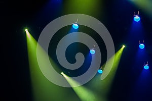 Blue and green rays of light through the smoke on stage. lighting equipment. Spotlight