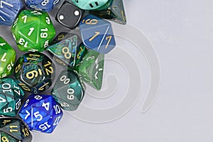 Blue and green roleplaying game RPG dice on side of gray background