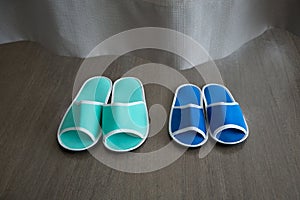 Blue and green slippers behind curtain in the hospital