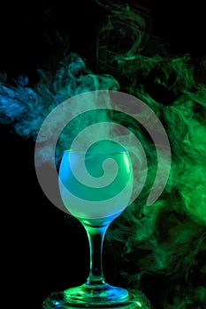 Blue and green smoke in a glass. Halloween.