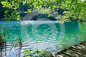 Blue/green, turquoise water in the morning, at Plitvice Lakes, Croatia, as seen from the wooden boardwalk bridge for tourists.